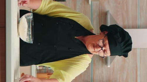 Woman Cracking Egg into Mixing Bowl in Kitchen