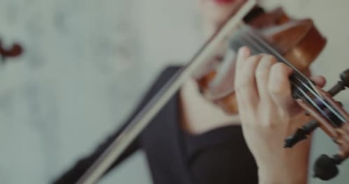 Close View of Female Musician Playing the Violins at Camera Indoor