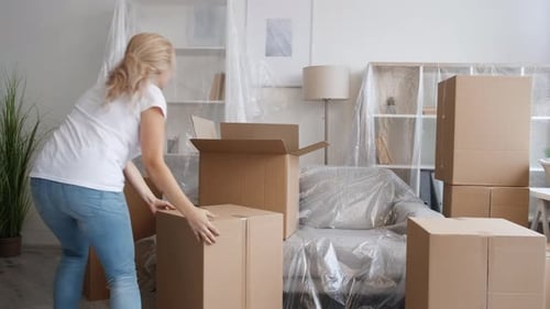 Woman Carrying Boxes into Home Interior