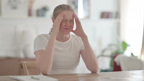 Beautiful Young Woman Having Headache While Sitting in Office