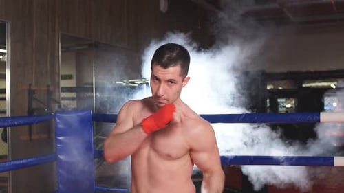Young Boxer Practicing Punches in Boxing Ring