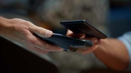 Businessman Hand Paying with Mobile Phone Over Pos Terminal with NFC Technology