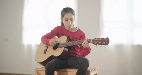 Young Girl Plays Acoustic Guitar Skillfully