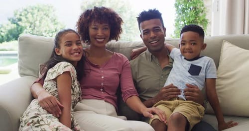 Smiling Family Together on Couch in Living Room