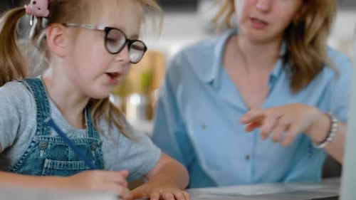 Girl Doing Homework with Woman Assisting