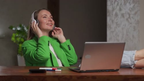 Woman Listening to Music With Headphones at Table