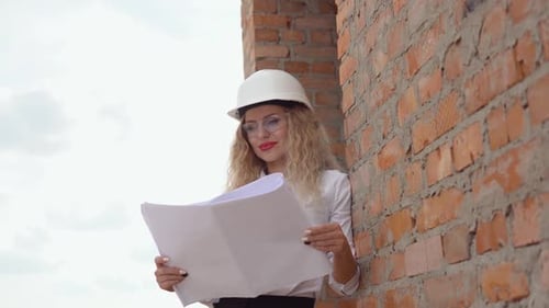 Architektin in Geschäftskleidung steht draußen auf der Baustelle