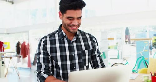 Young Adult Working on Laptop in Bright Workspace