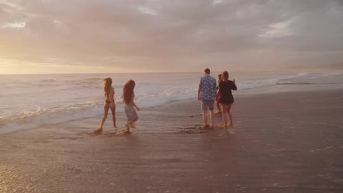 Carefree Friends on Beach at Sunset