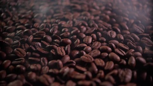 Ароматные кофейные зерна в процессе обжарки с присутствием небольшого количества дыма