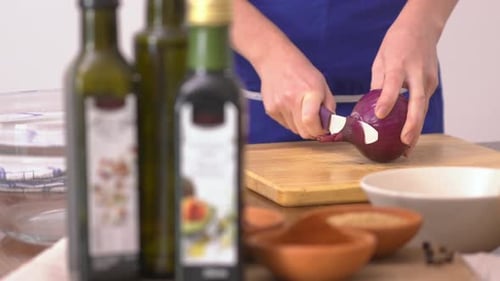 Woman Cuts Red Onion in Kitchen for Recipe