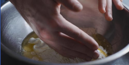 Hands Mixing Dough in Metal Bowl Close Up