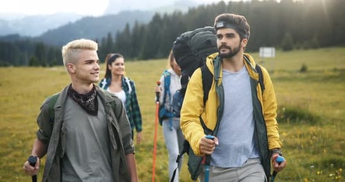 Friends Hiking in Mountain Meadow with Hiking Poles