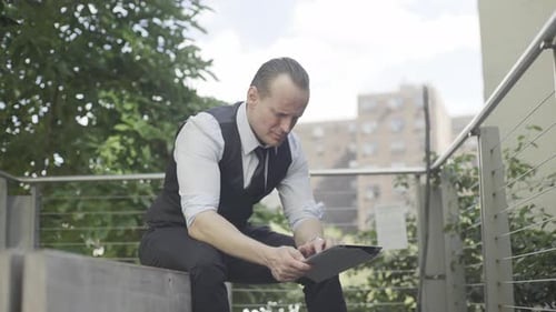 Man Uses Tablet Outside on Urban Day