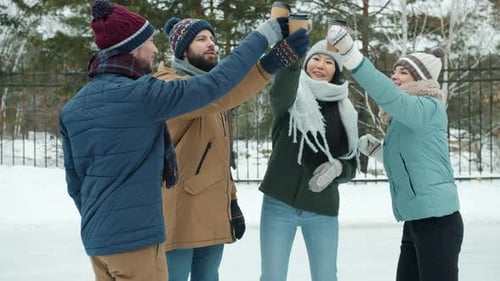 Friends Toasting Coffee Together in the Winter Snow
