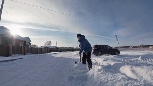 Man Shoveling Snow on Suburban Street in Winter