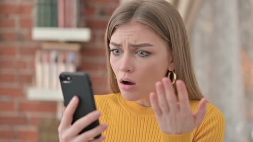 Annoyed Young Woman Reacting to Smartphone Content