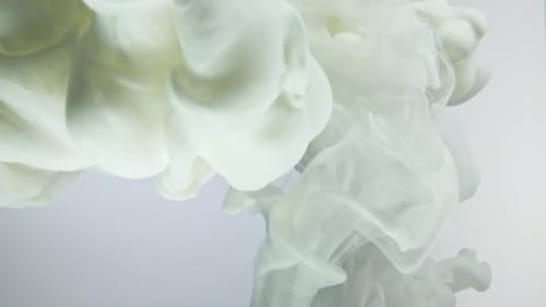 White nacreous paint in water against white background.