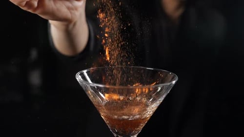 Bartender Igniting Cocktail with Orange Powder