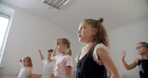 Children Exercise Together in an Indoor Classroom