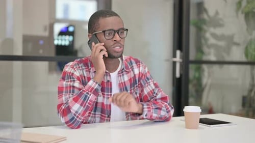 African Man Talking on Smartphone in Office