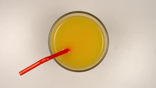 Refreshing Yellow Drink with Straw Overhead