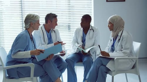 Front view of Multi-ethnic doctors discussing over medical files in hospital