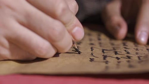 Wörter, die mit Stift auf Papier in historischer Umgebung geschrieben wurden.