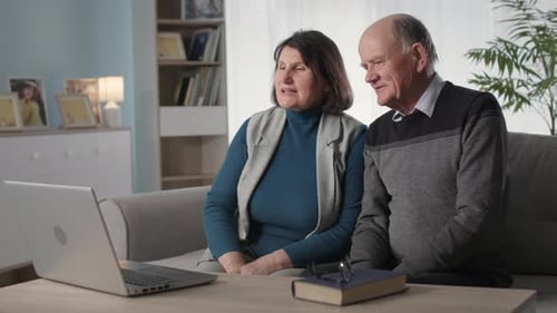 Senior Couple Video Chatting on Laptop at Home