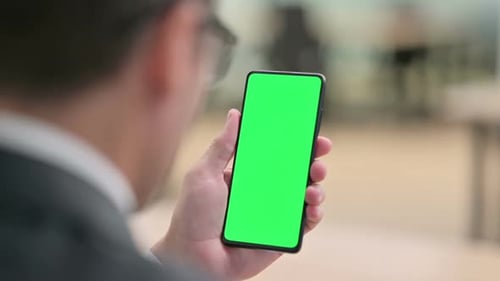 Hand Holding and Tapping Smartphone with Green Screen
