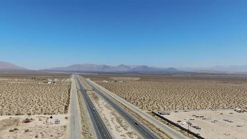 Aerial View of Road in the Middle of the Desert Under Blue Sky in California Desert