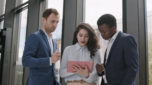 Three Diverse Businesspeople Using Tablet in Office