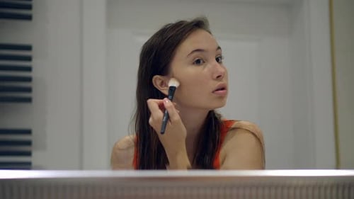 Brunette Woman Applying Make Up in Bathroom