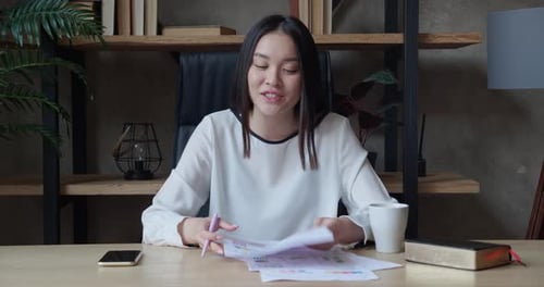 Smiling Young Asian Woman Blogger Vlogger Influencer Sit at Office Speaking Looking at Camera