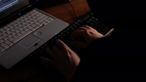 Person Typing on Keyboard at Night
