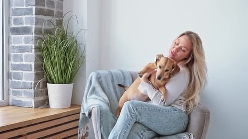 Woman Hugging her Adorable Pet Dog at Home