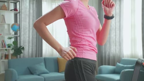 Side View Of Asian Woman Running On A Treadmill At Home