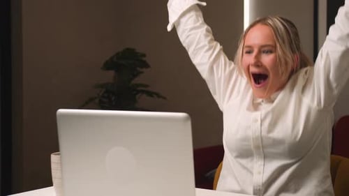 Woman Celebrates Good News on Laptop