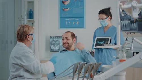 Patient with Dentist and Assistant in Dental Office