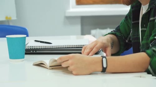 Person Reading and Taking Notes at Modern Desk