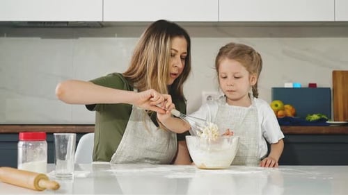 Woman and Child Mixing Ingredients in Kitchen