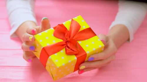 Hands Holding a Brightly Wrapped Birthday Gift