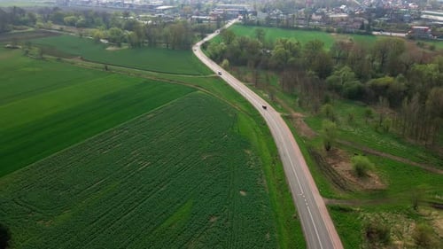 Car Driving on Road Among Agricultural Fields