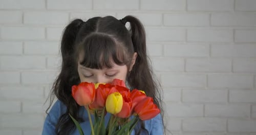 Girl with Flowers in Front of White Wall