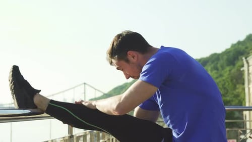 Man Stretching Leg in City Park