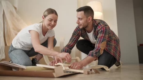 Young Adults Moving in New Home, Couple Moving in Assembling Chair Furniture, Young Interracial
