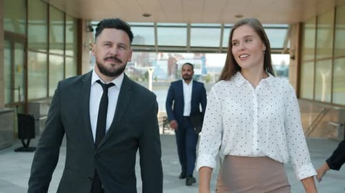 Slow Motion Dolly Shot Portrait of Cheerful Man and Woman Colleagues Walking Outdoors Near Office