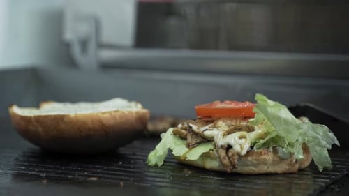 Fast Food, Juicy Burger with Cheese Meat Cutlet and Fresh Lettuce Cooked on Grill in Kitchen in Cafe