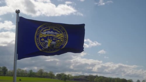 Nebraska State Flag Waving with Blue Sky Background