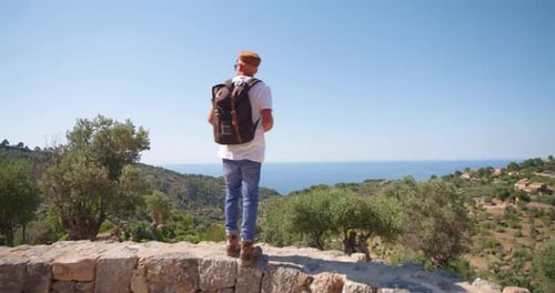 Traveler adult man near sea coast admiring mountain view